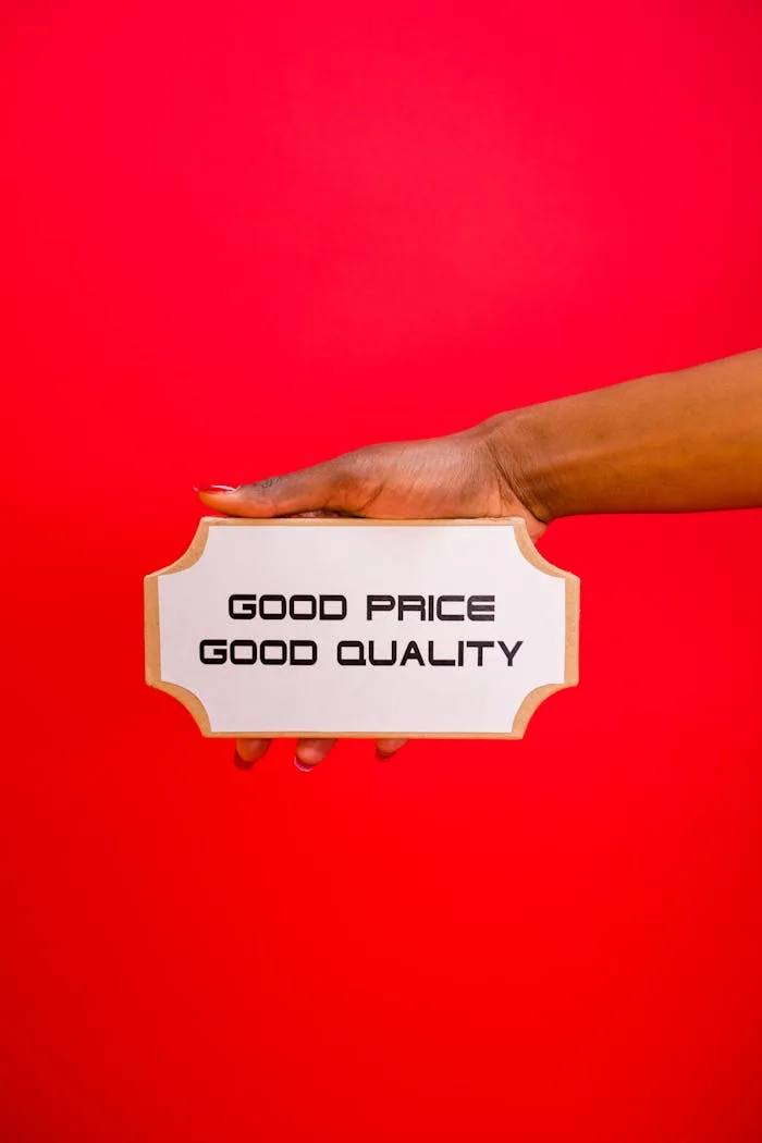 gallery-2 A hand holding a sign with 'Good Price, Good Quality' text against a bright red background.