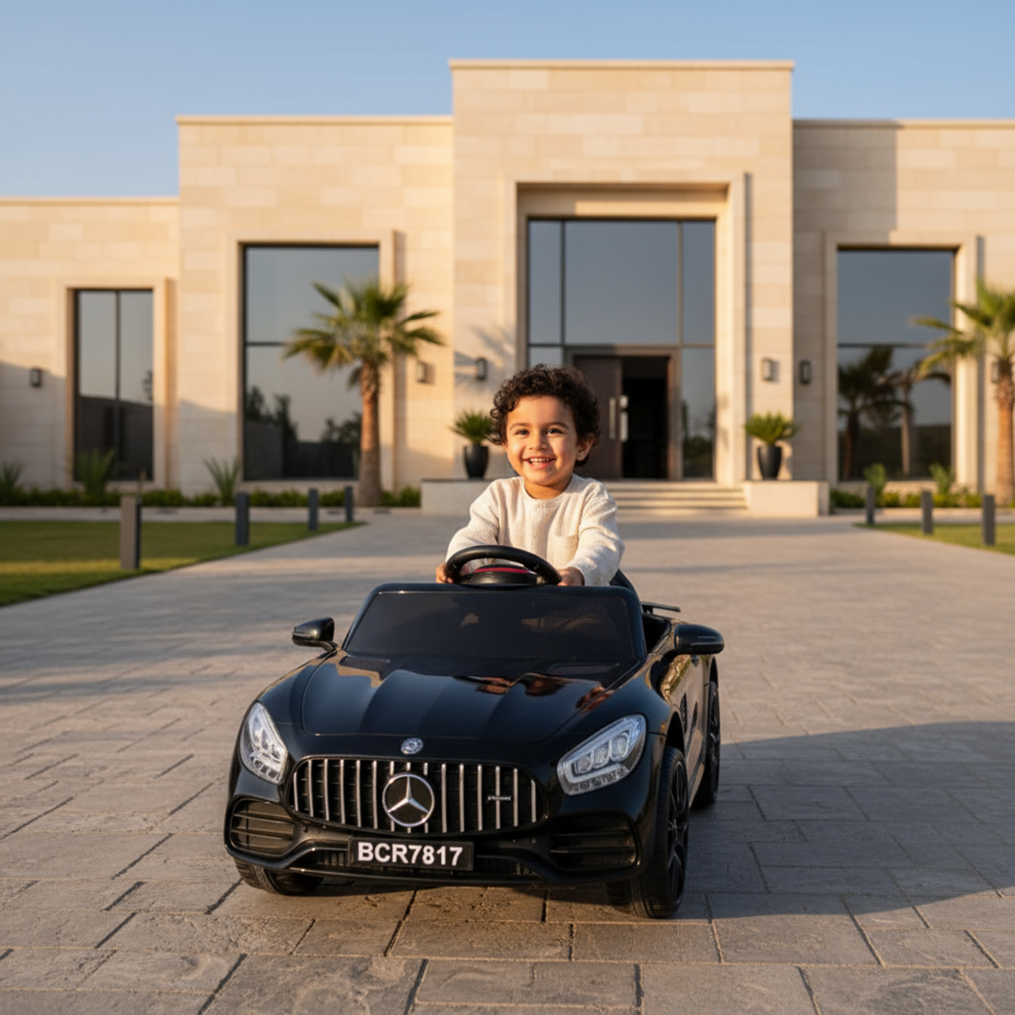 طفل يقود سيارة مرسيدس اطفال كهربائية سوداء أمام منزل
